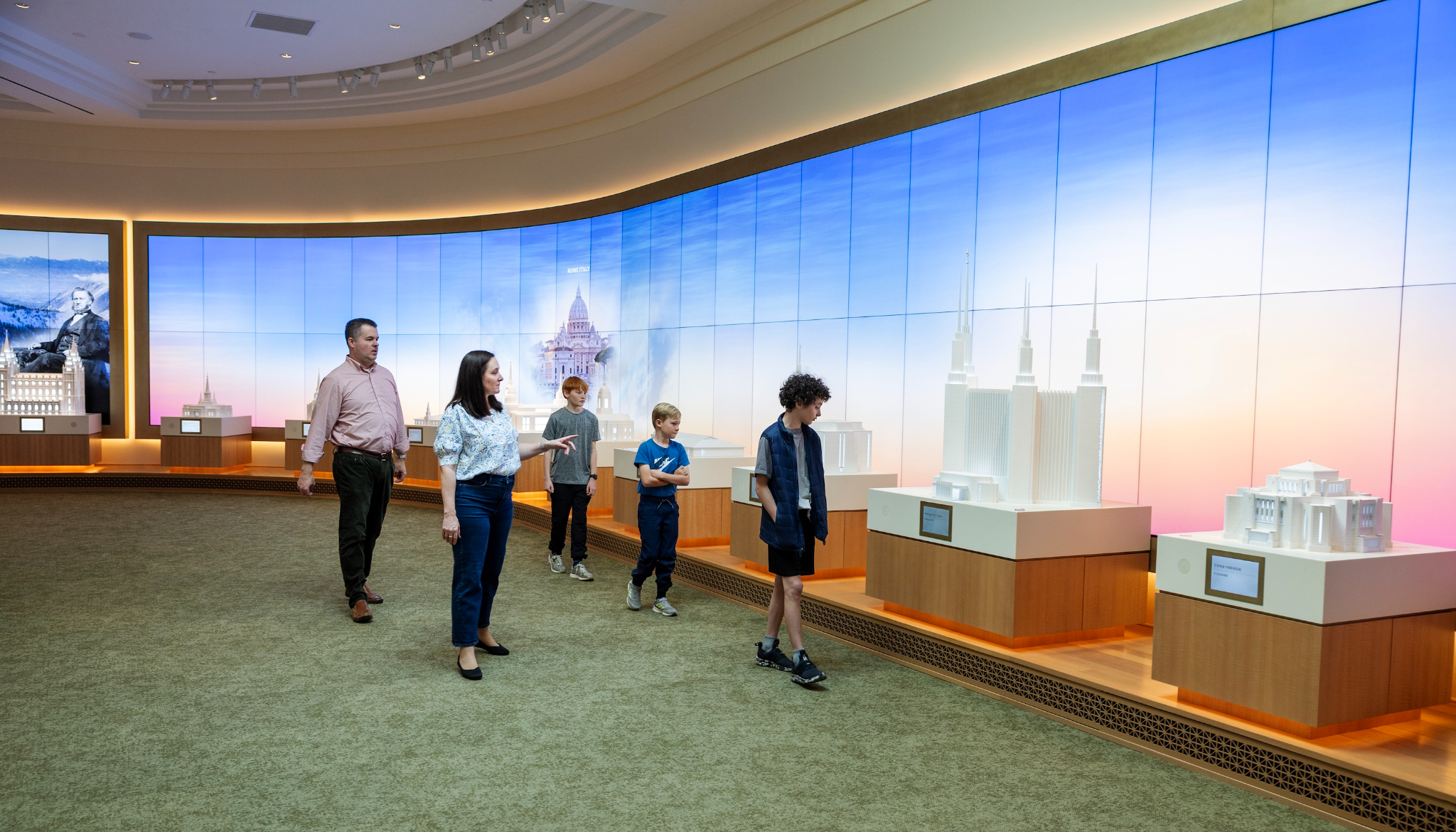 Family viewing the long gallery of temple models at the Salt Lake Temple Visitor Center